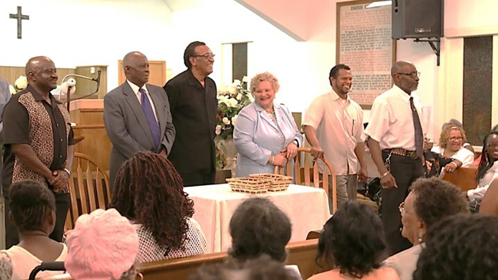 Photograph of Shankeville’s 2014 Annual Homecoming event, with Homecoming presidents from Jasper and Newton County settlements standing at the front of a church, and Homecoming attendees seated around them.